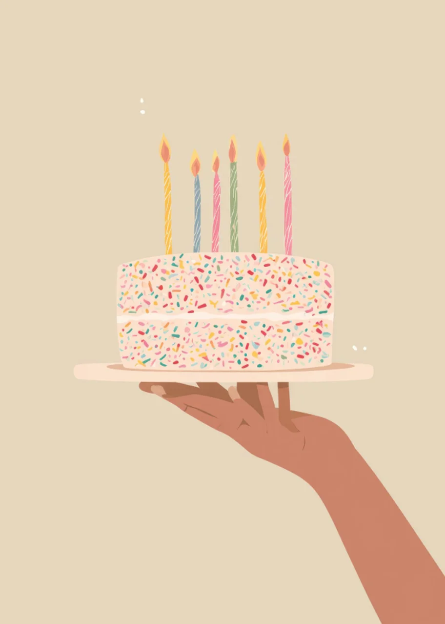 Hand holding a sprinkle birthday cake